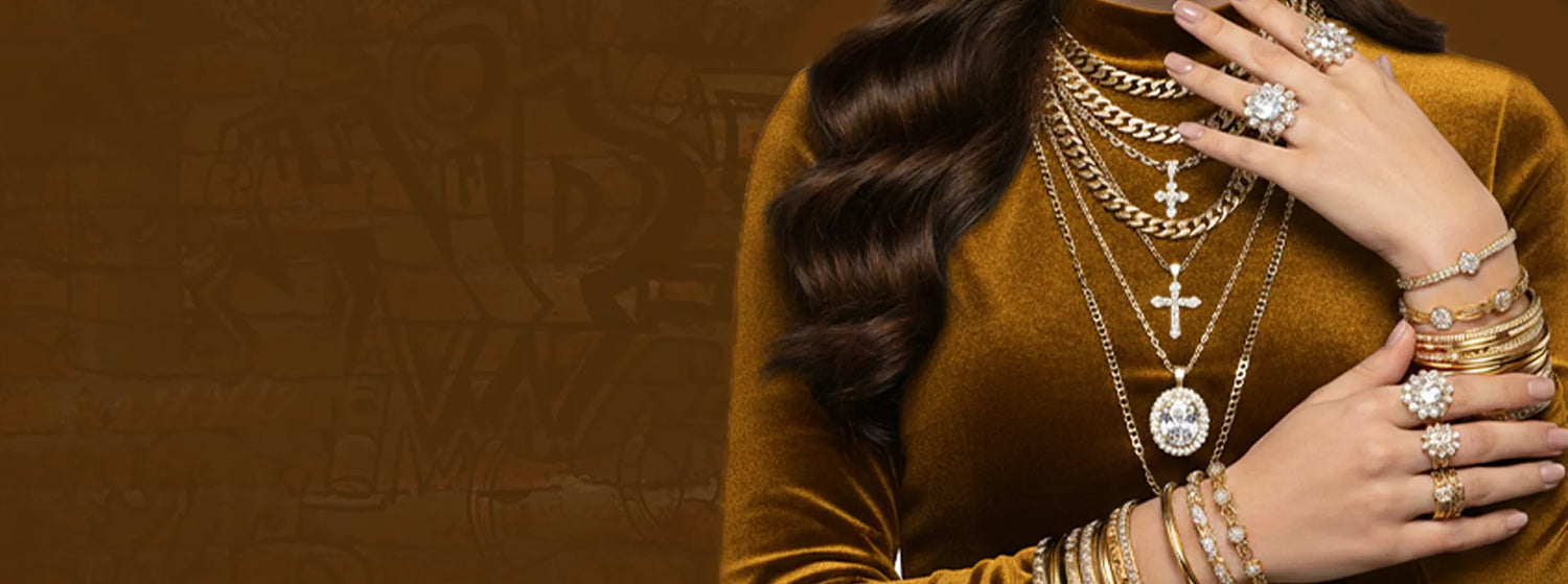 Woman wearing multiple gold necklaces and rings on a brown background